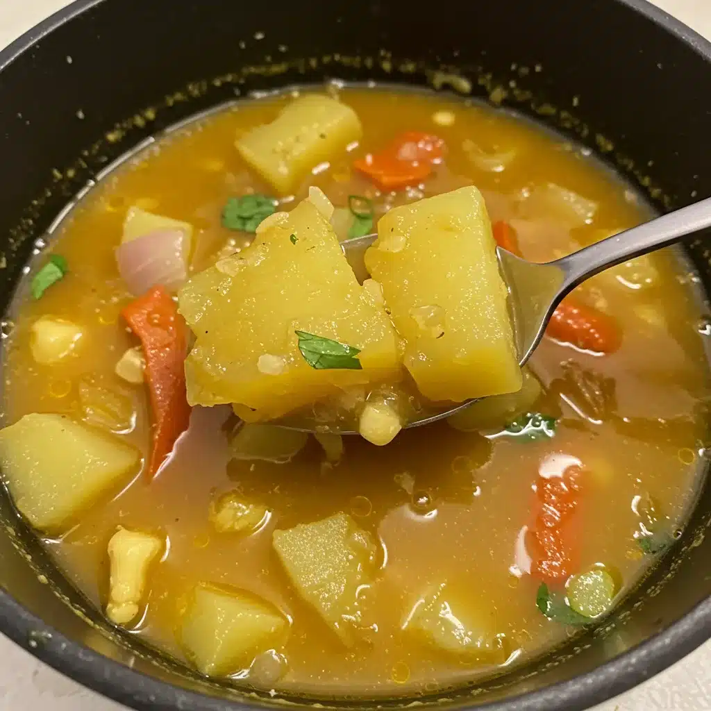 Bowl of Ecuadorian-style vegetable soup with chunks of yellow squash, red bell pepper, corn, and herbs in a golden broth.