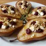 Baked pears topped with feta, honey, and cranberries on a plate