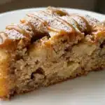 Slice of delicious German Apple Cake garnished with cinnamon and apples, representing fall flavors.